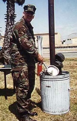 A Seabee mess management specialist washing his mess kit