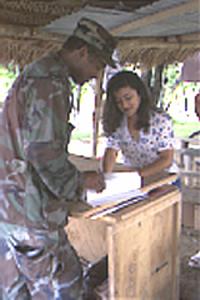 Food service NCOIC Master Sgt. Madison Rayford, 420th Engineer Brigade, Bryan, Texas and Brenda Adalgisa, Guatemalan KP, discuss the food schedule for the upcoming week.  Rayford, from Huntsville, Texas, provides a hot breakfast and supper to more than 250 Army Reservists on annual training during operation New Horizons '99.